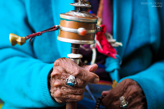 rotation buddhist prayer wheel at old woman's hand, Nepal